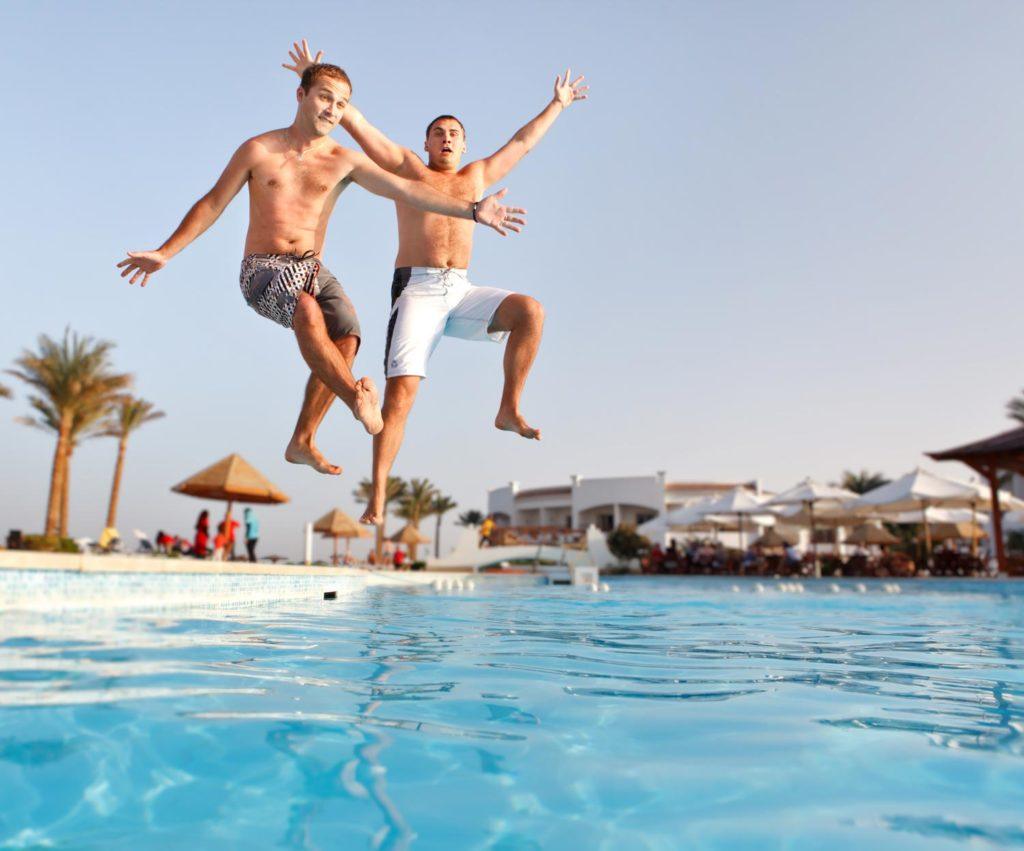 two Austin gynecomastia patients jumping into a pool